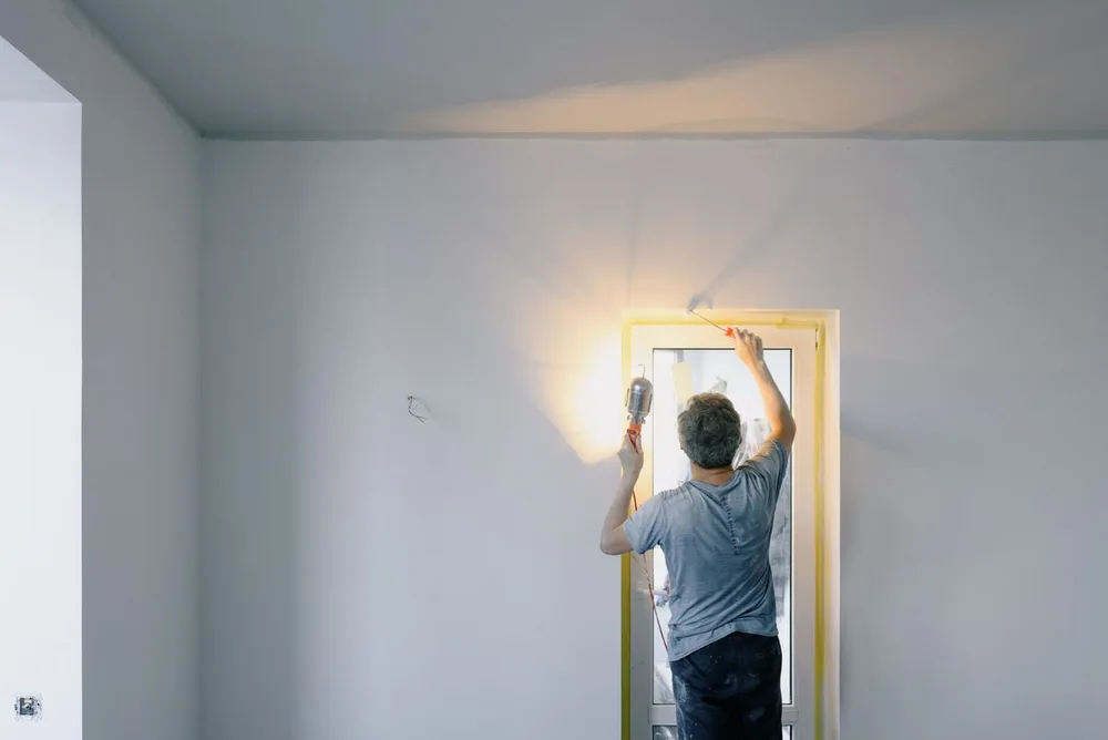Handyman carrying out finishing work beside an interior door
