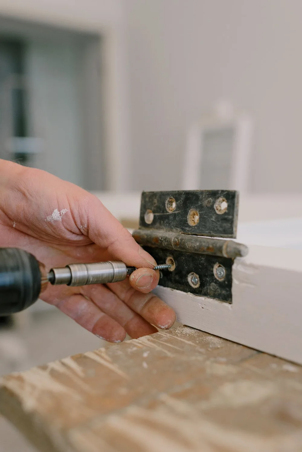 Close-up of a handyman fitting a metal hinge